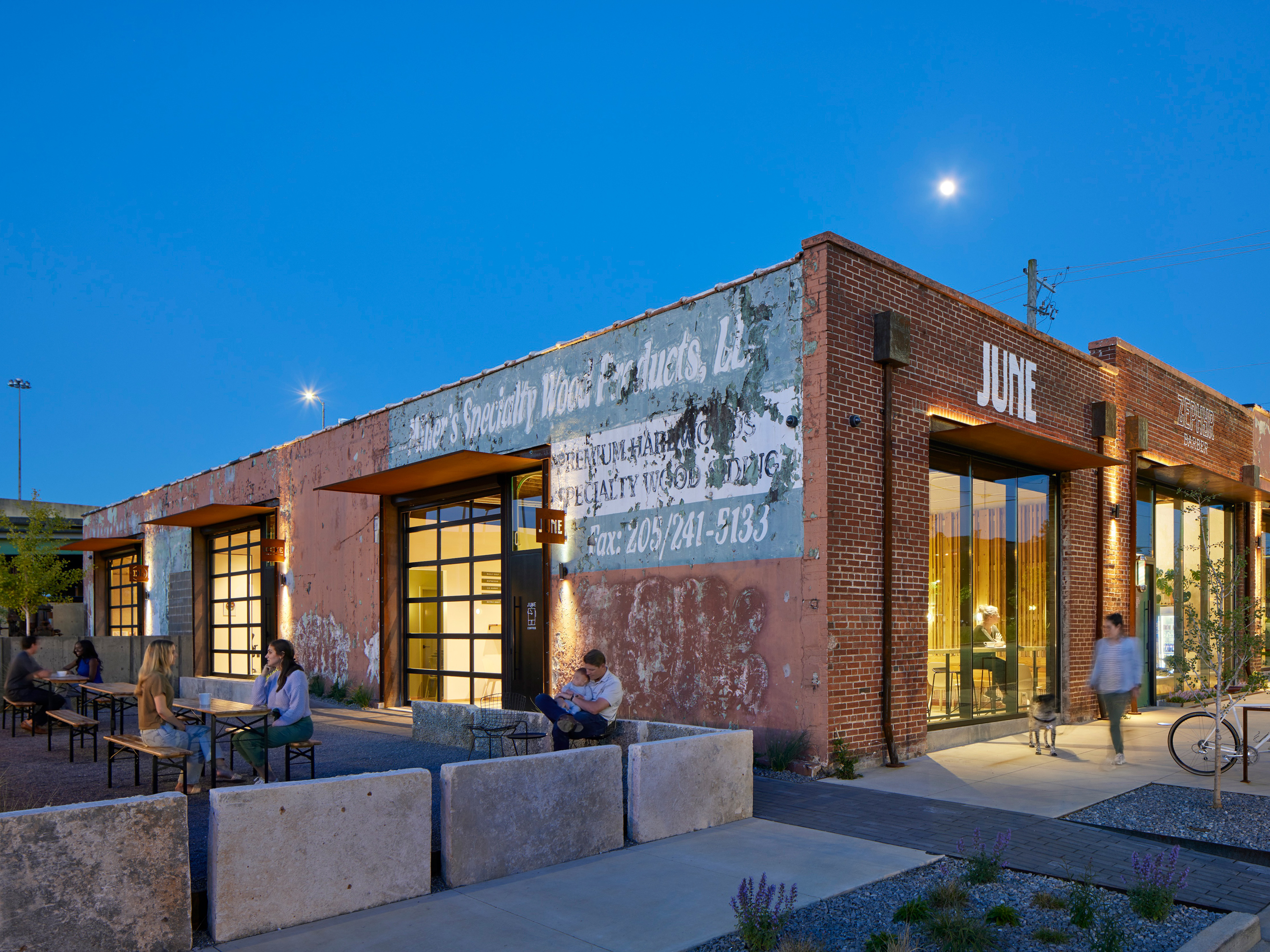 Evening exterior of the Bandsaw Building, a renovated historic brick warehouse with five commercial spaces.