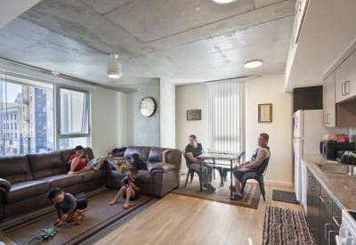 Family gathered in their living room at 222 Taylor Street, affordable housing in San Francisco
