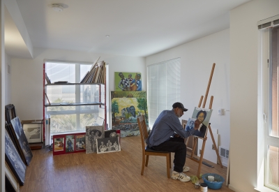 Resident painting inside of his apartment in Dr. George Davis Senior Building in San Francisco.