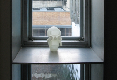 A pivot window in closed position with a small astronaut figurine on it at Shotwell Design Lab in San Francisco. 