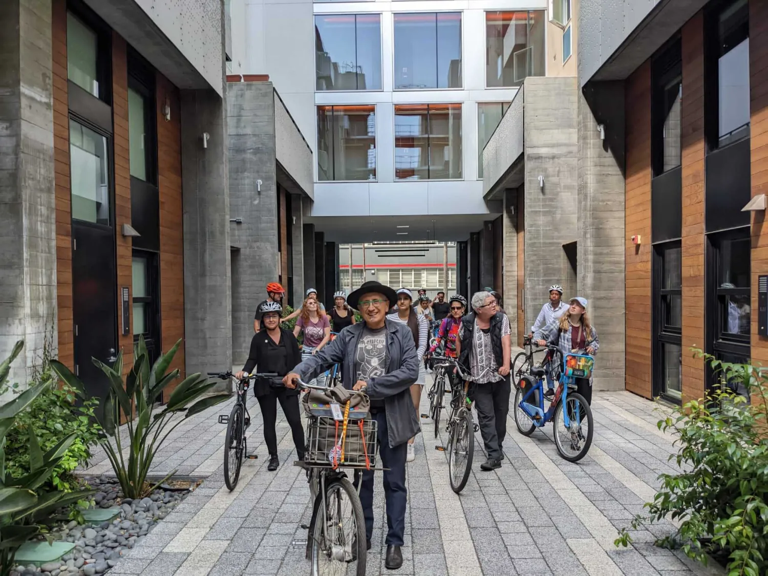 David Baker and other people walking through the Five88 Courtyard with their bikes in San Francisco.