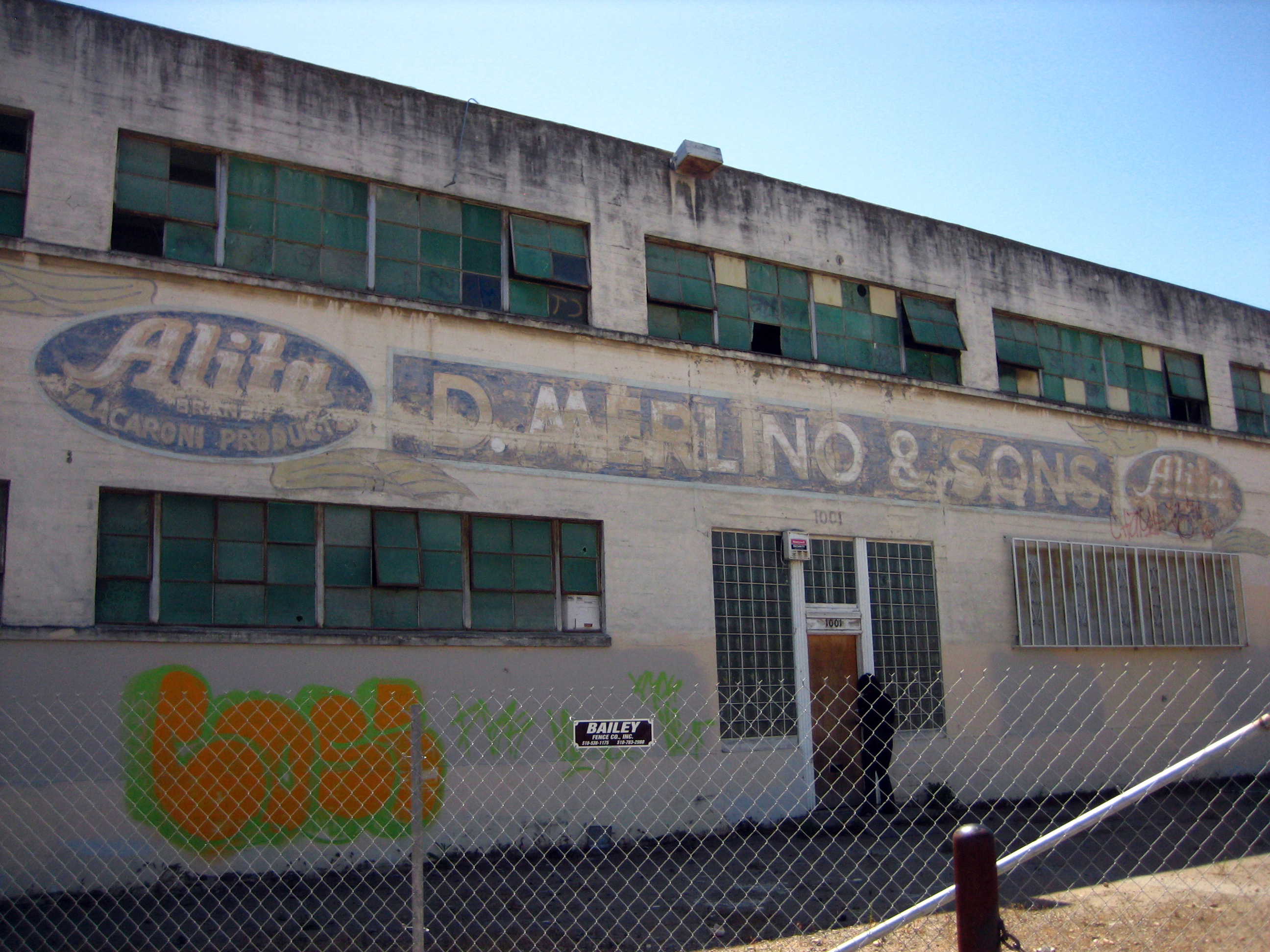 Exterior of the degraded pasta factory building before renovation at Tassafaronga Village in East Oakland, CA.