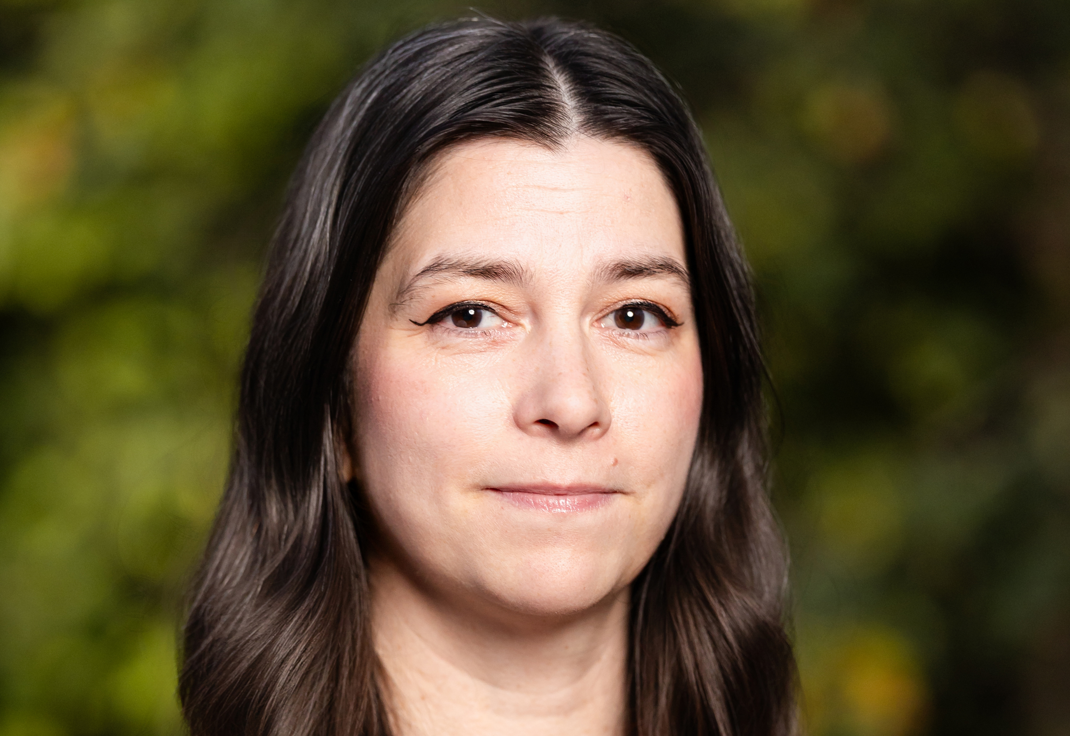 Headshot of woman with long dark brown hair parted in center
