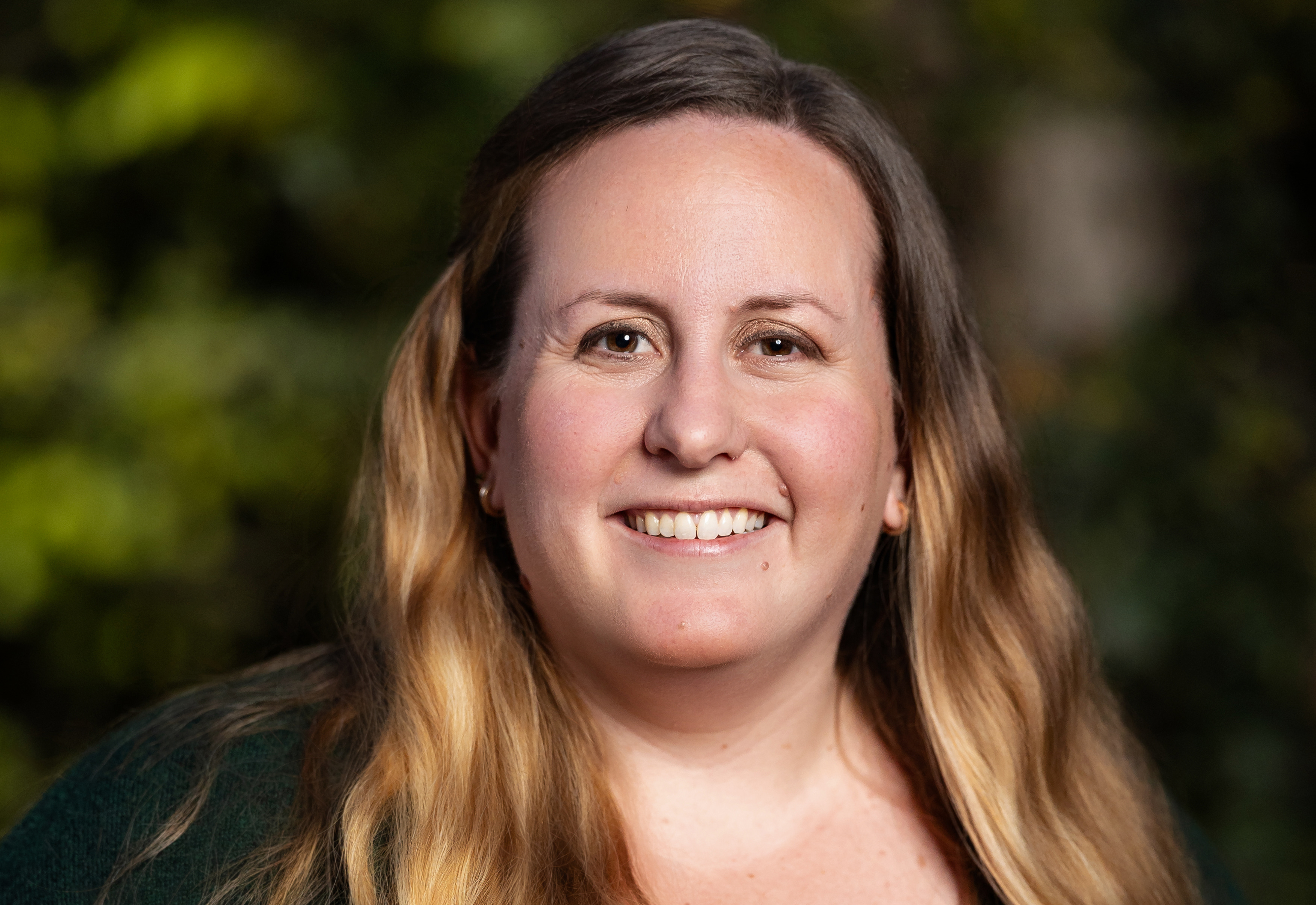 Headshot of woman with long blond hair clipped on the side