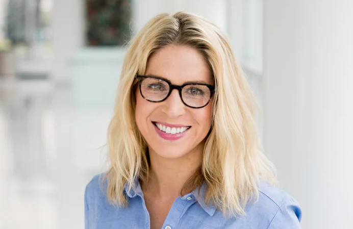 Headshot of blonde woman with glasses and blue shirt