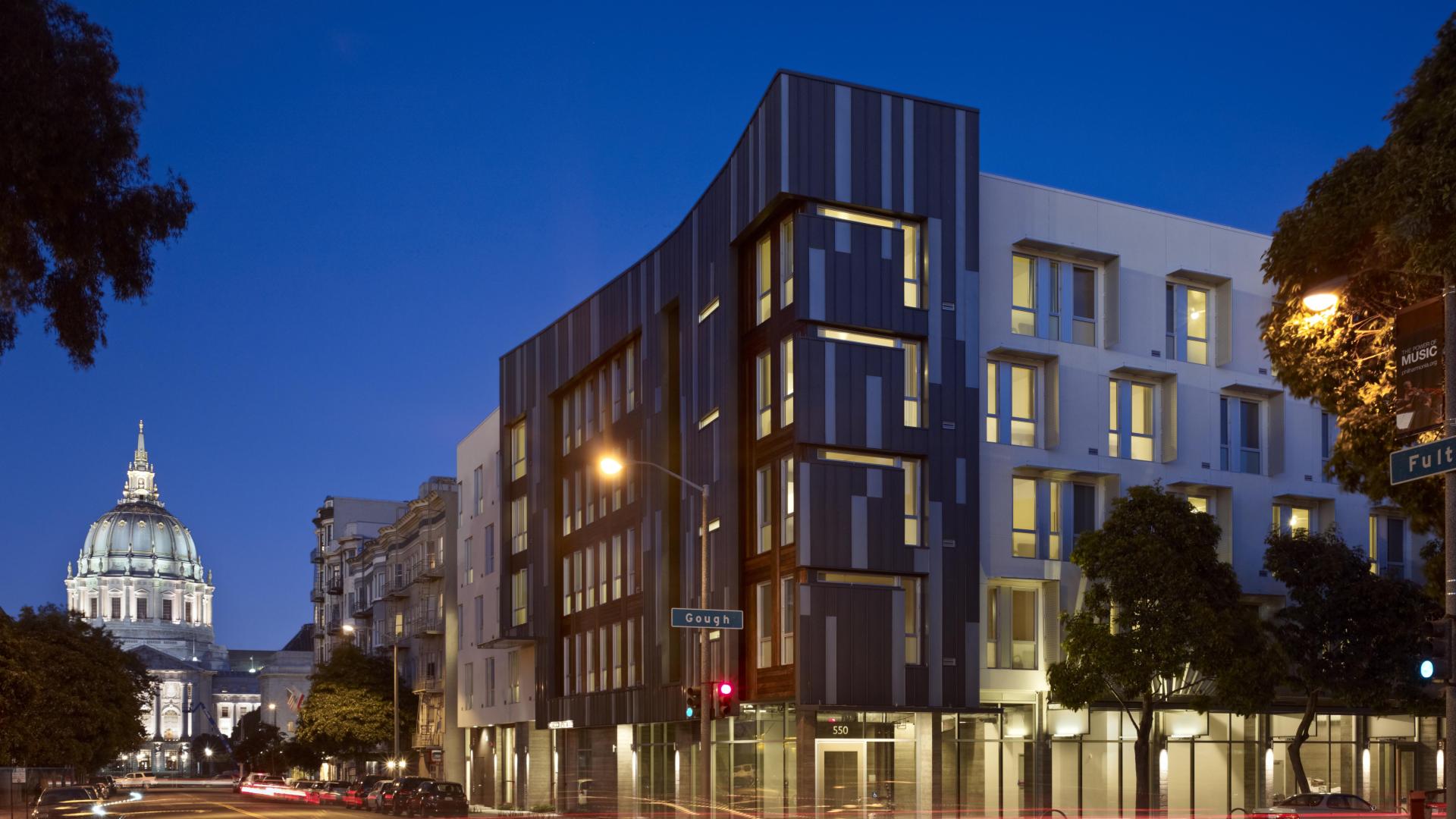 Night view of Richardson Apartments with City Hall dome in background in San Francisco.