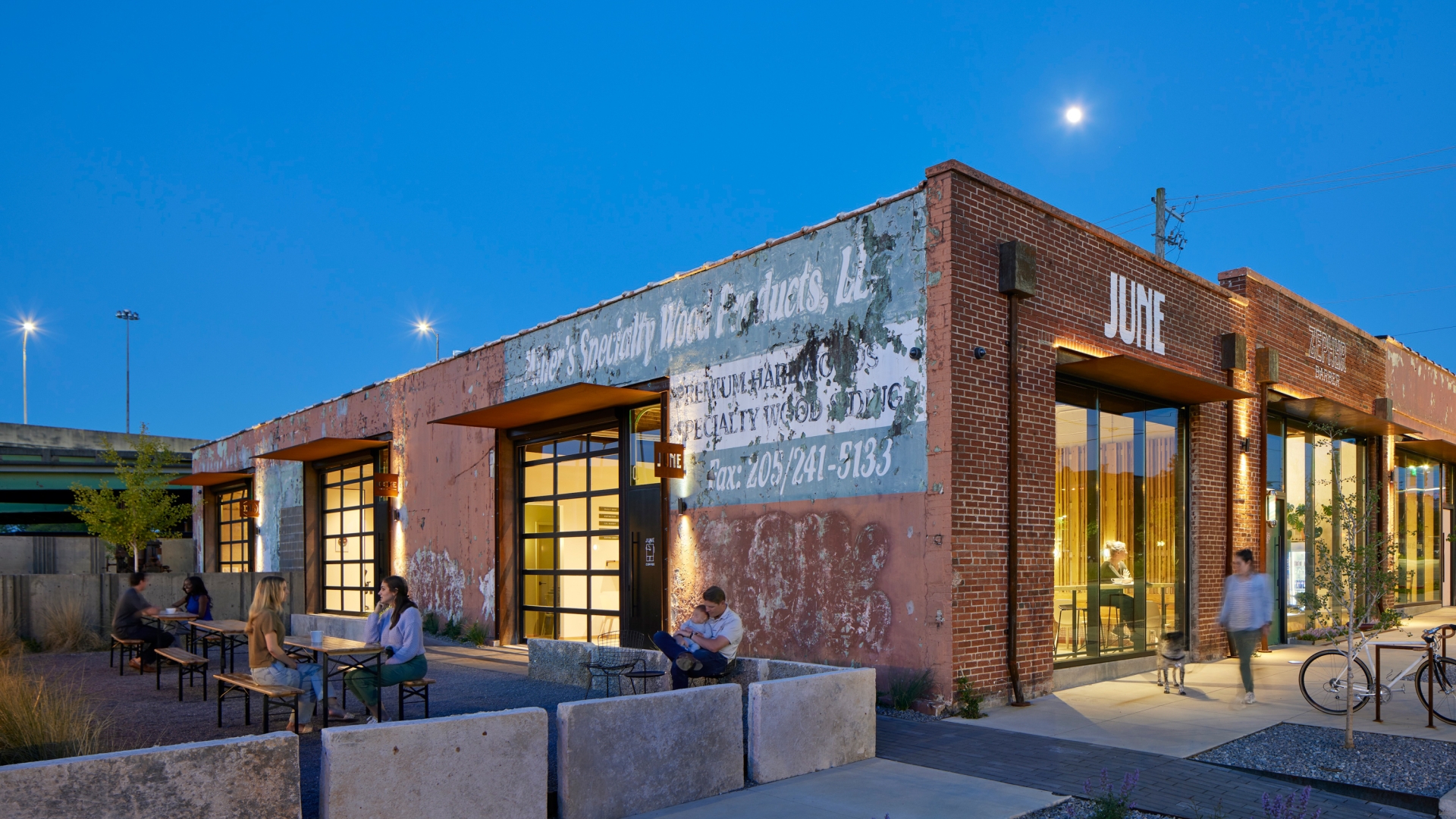 View of the multiple people enjoying the open courtyard at dusk at the Bandsaw Building in Birmingham, Alabama.