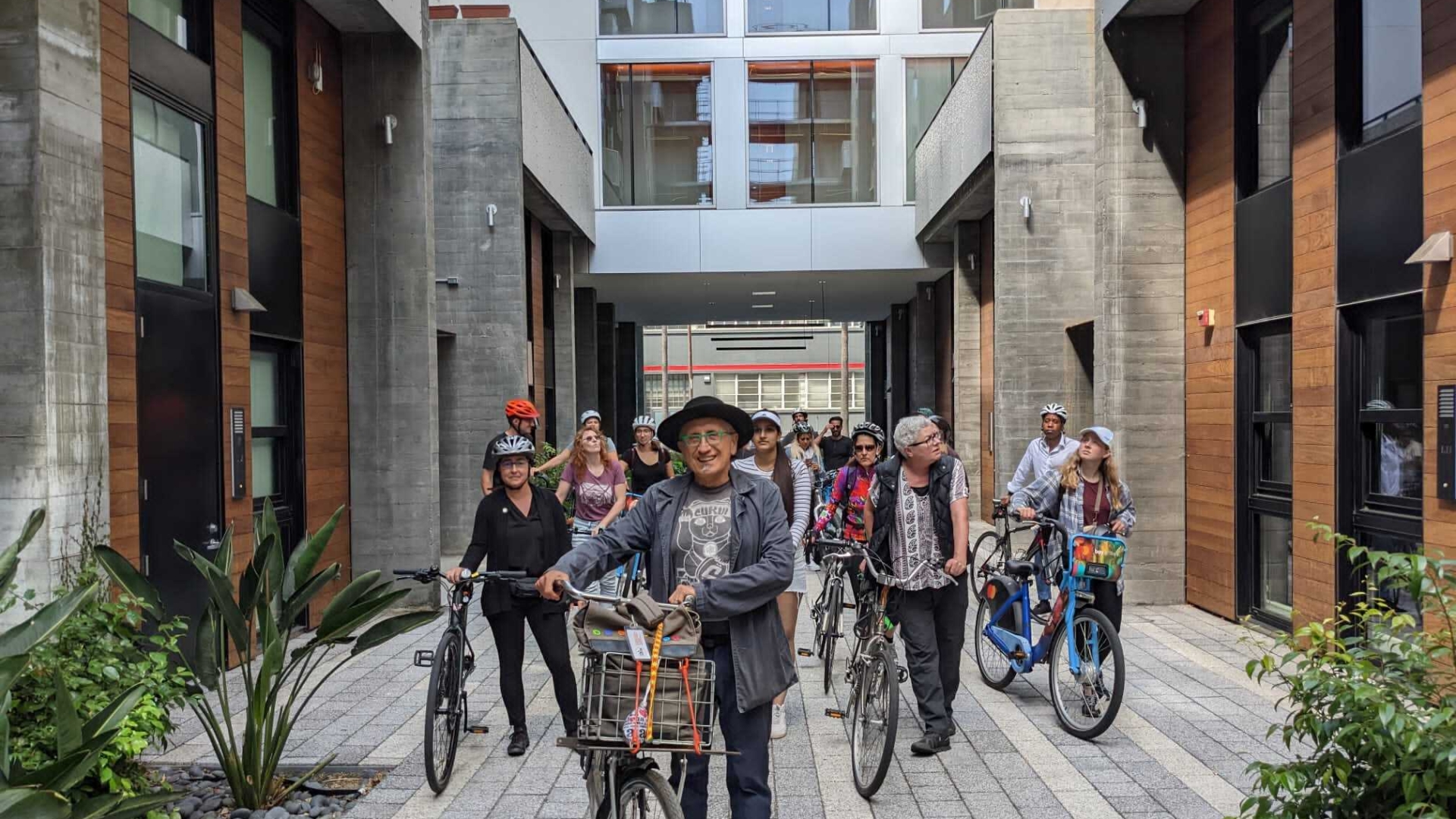 David Baker and other people walking through the Five88 Courtyard with their bikes in San Francisco.