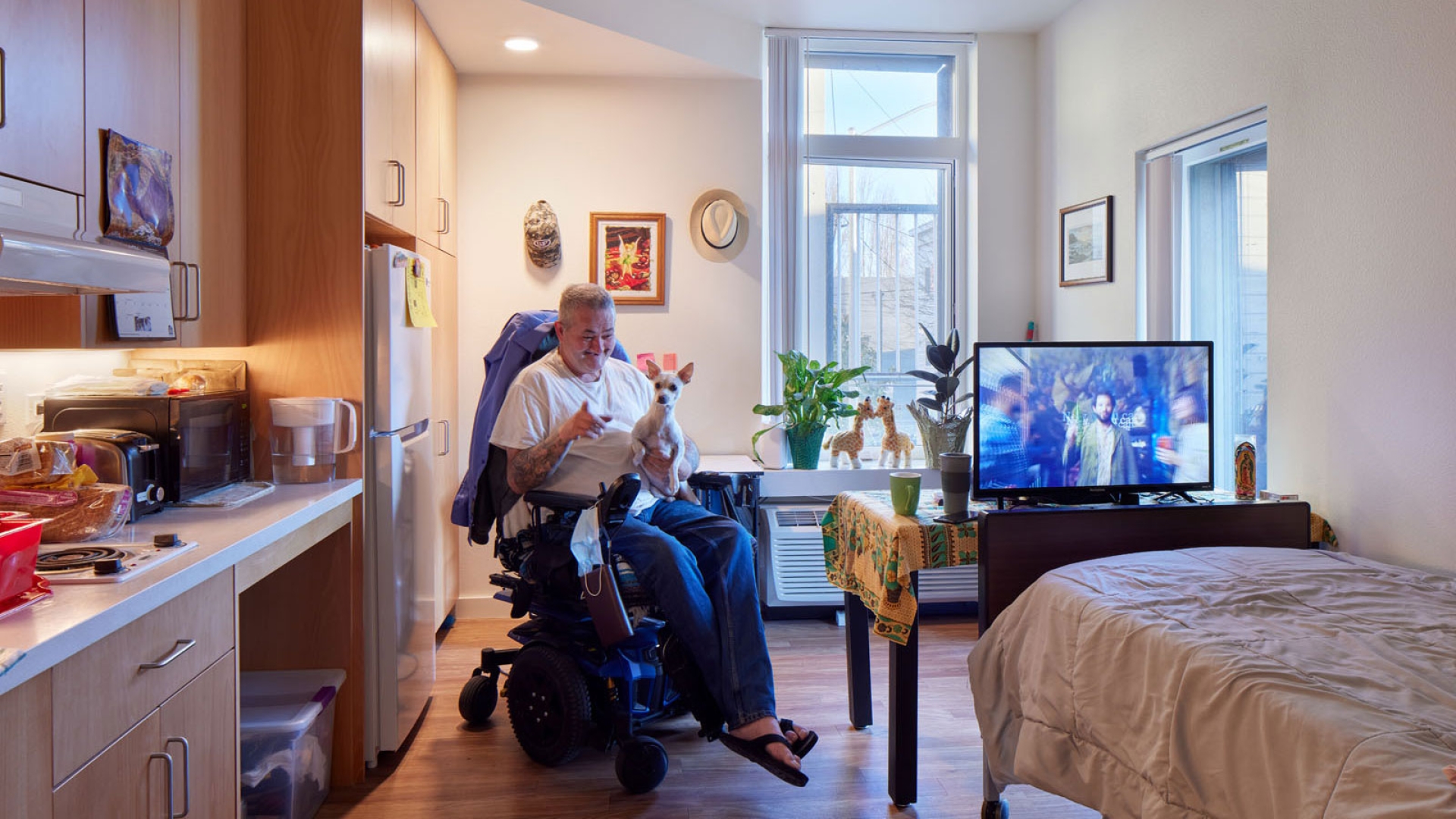 Resident sitting in his wheelchair inside his unit at Tahanan Supportive Housing in San Francisco.