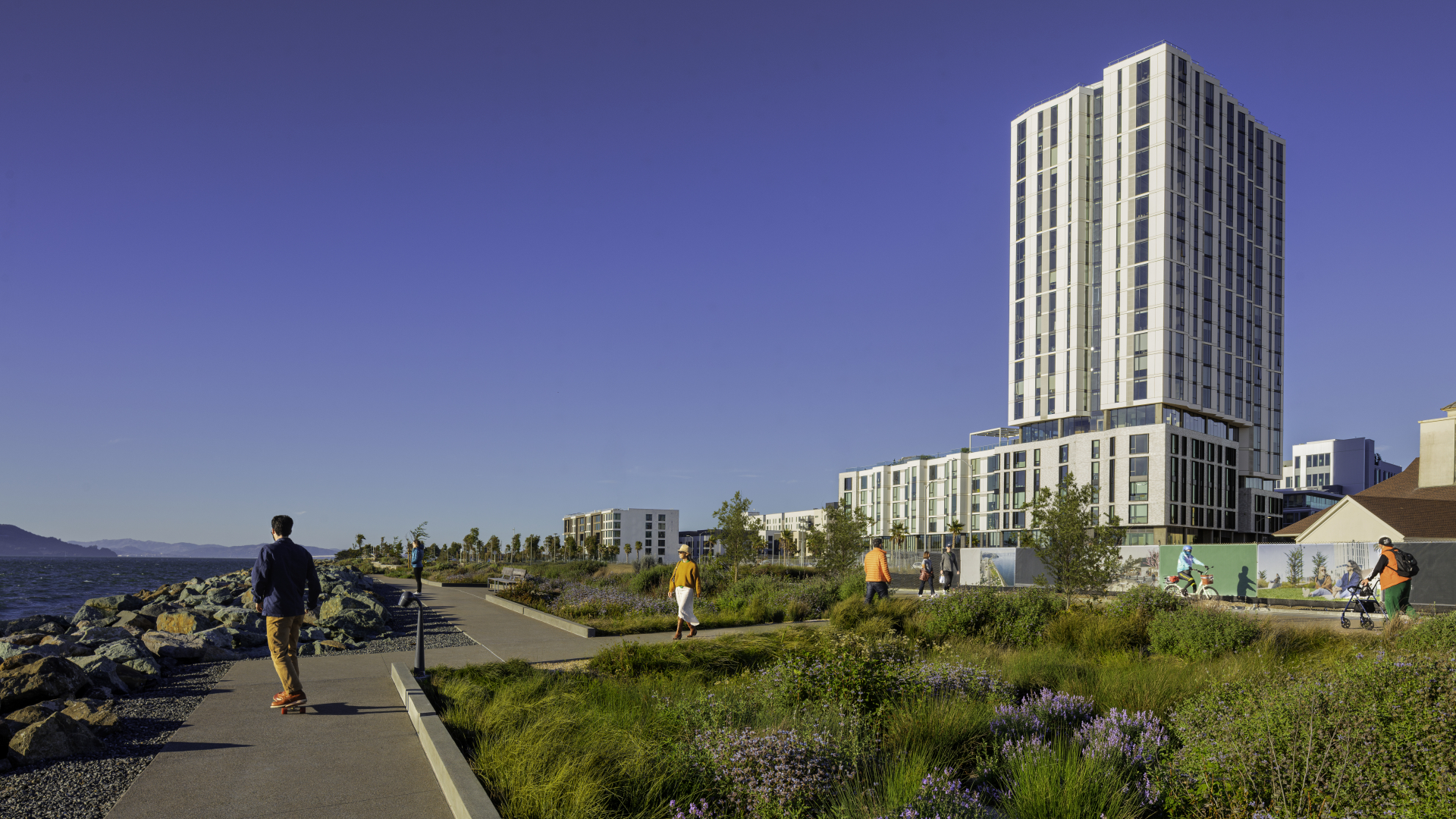 Exterior view of white apartment building with park path walker