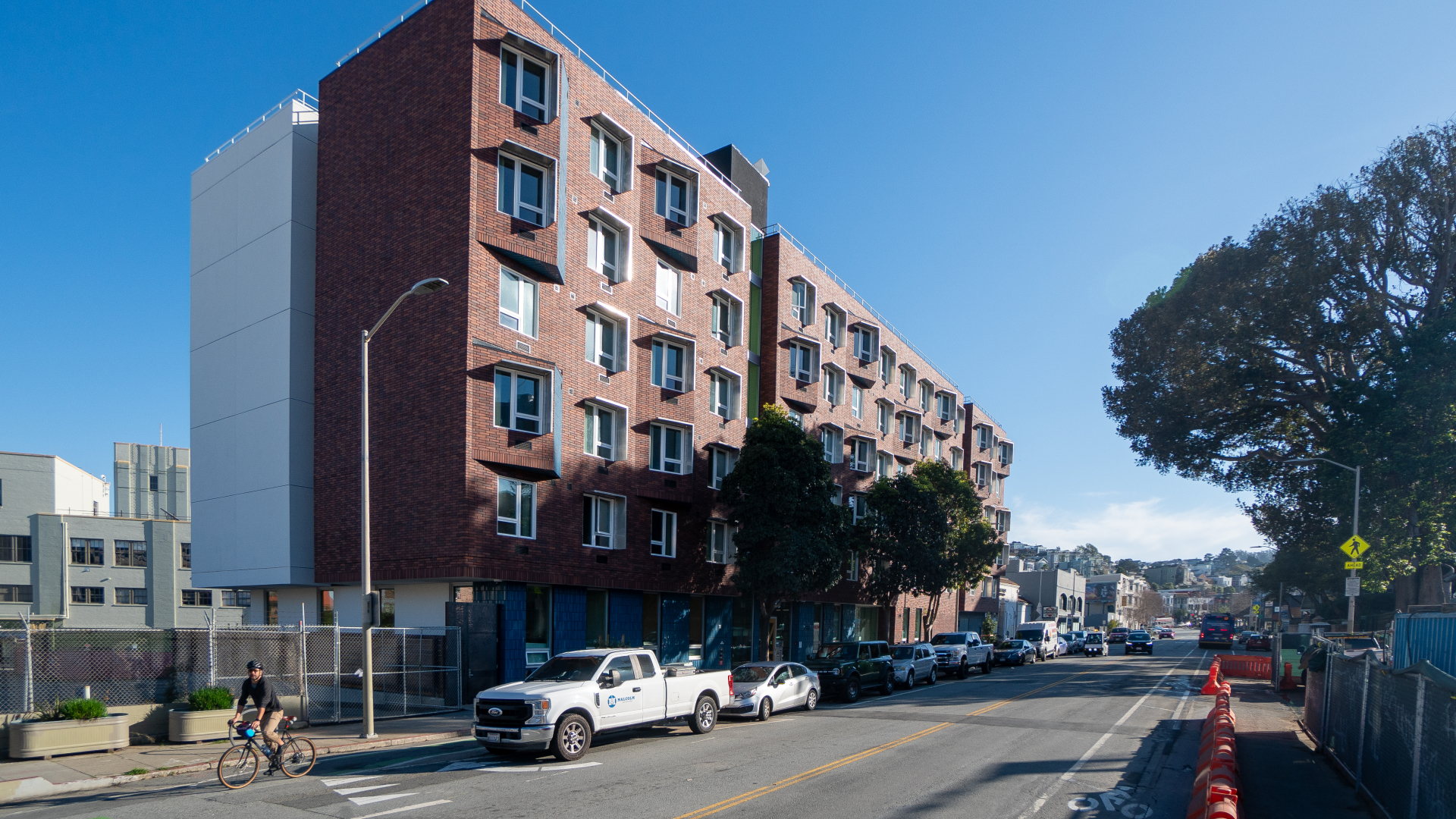 Street view of red brick apartment building with angular accents