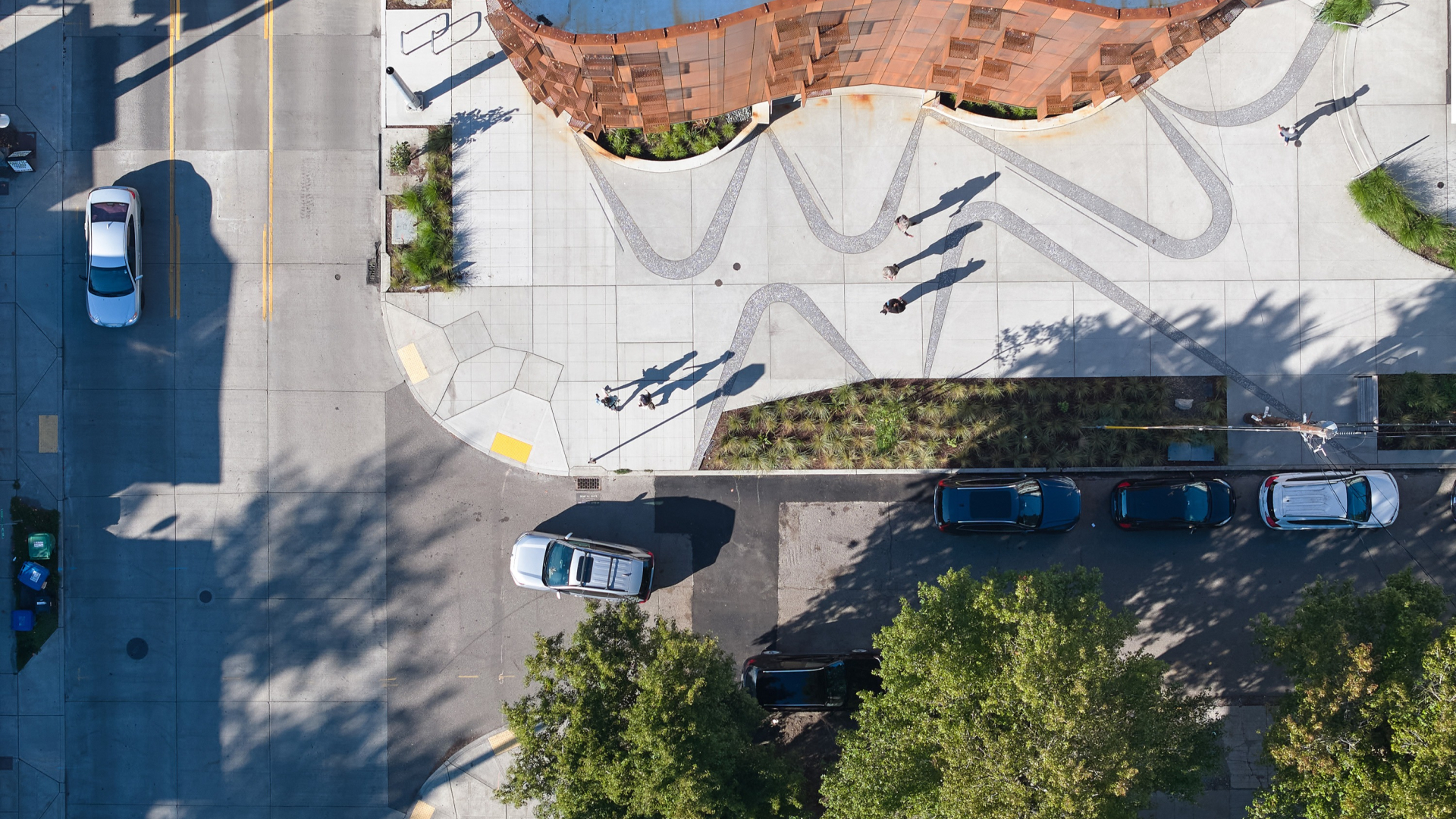 Aerial view of the corner of an apartment community showing plaza and connection to street