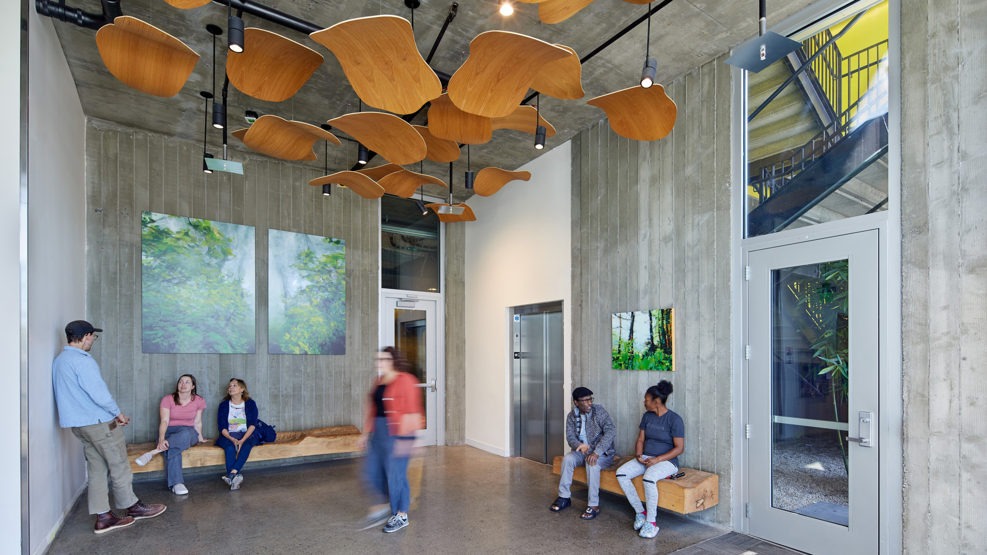 Lobby area with wood ceiling tiles and several people