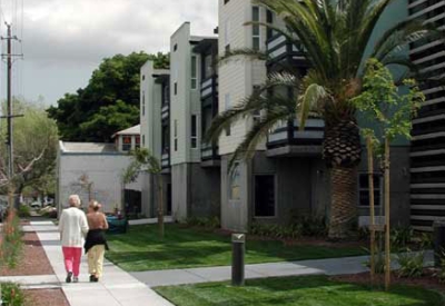 Two people walking on the sidewalk adjacent to View across Lenzen Avenue.