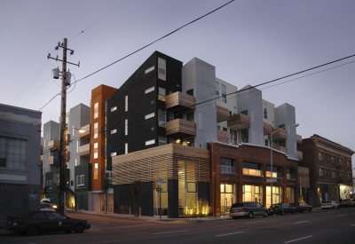 Exterior street view at dusk of Folsom-Dore Supportive Apartments in San Francisco, California.