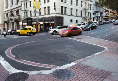 Image of an intersection that indicates a with a water cistern with a large circle brick at the intersection.