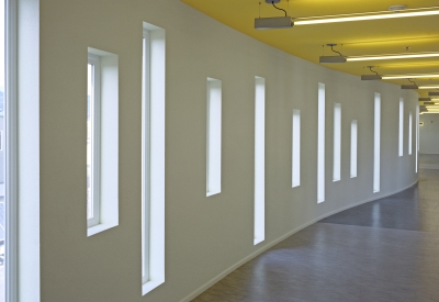 Interior corridor showing curved wall, window pattern, and yellow ceiling at Tassafaronga Village in East Oakland, CA. 