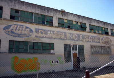 Exterior of the degraded pasta factory building before renovation at Tassafaronga Village in East Oakland, CA.