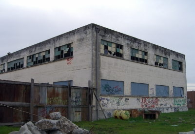 Exterior of the degraded pasta factory building before renovation at Tassafaronga Village in East Oakland, CA.