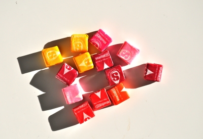 Handful of pink, yellow, and red starburst laying on a white background.