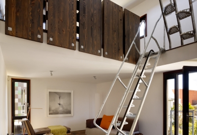 Interior view of the entrance, living room and second and third level metal stairs inside Zero Cottage in San Francisco.