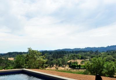 Two women sitting by the pool overlooking the hills and mountains at Healdsburg Rural House in Healdsburg, California.