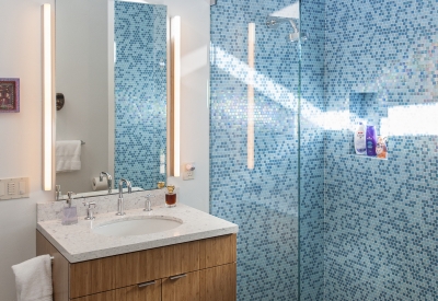 Guest bathroom with sink and glass shower covered in blue tile inside Healdsburg Rural House in Healdsburg, California.