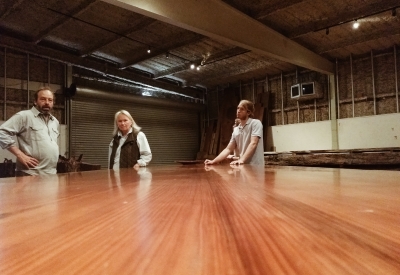 Three people standing beside a wood slab for Hotel Healdsburg in Healdsburg, Ca.