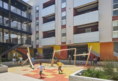 Children playing in the courtyard playground in Edwina Benner Plaza in Sunnyvale, Ca.