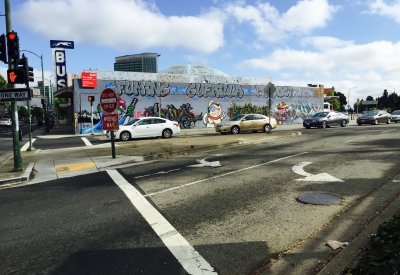 Exterior street view of the side of David Baker Architects Office covered in street art in Oakland, California.