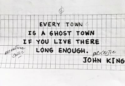 Sign for the previous 555 Larkin site that states "Every town is a ghost town if you live there long enough. - John King"