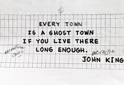 Sign for the previous 555 Larkin site that states "Every town is a ghost town if you live there long enough. - John King"