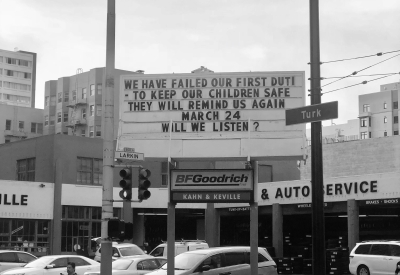 Sign at previous 555 Larkin site that states "We have failed our first duty. To keep our children safe. They will remind us again. March 24. Will we listen?"