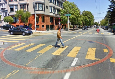 Image of an intersection that indicates a with a water cistern with a large circle brick at the intersection.