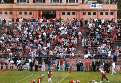 Football stadium with people in the stands and Parkview Commons in the background.