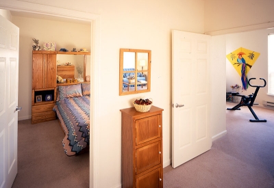 View into apartment bedroom and living room at Plaza Maria in San Jose, California.