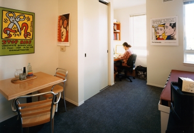 Resident working at his desk in his studio unit at Manville Hall in Berkeley, California.