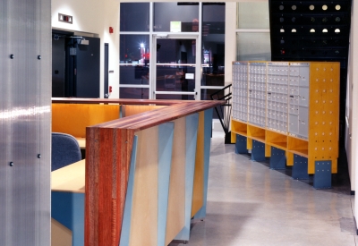 Entry lobby at night with the reception desk and mailboxes at Pensione Esperanza in San Jose, California.