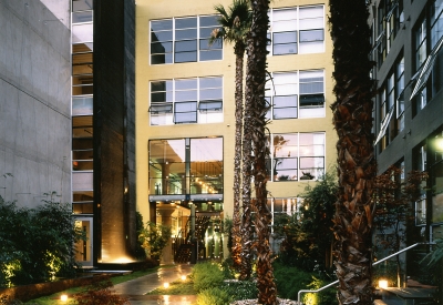 Exterior view of the entry courtyard to 1500 Park Avenue Lofts at dusk in Emeryville, California.