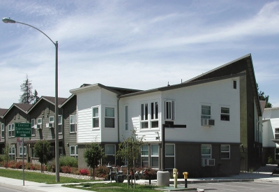 Exterior view of the community building and surface parking at Stoney Pine Villa in Sunnyvale, California.