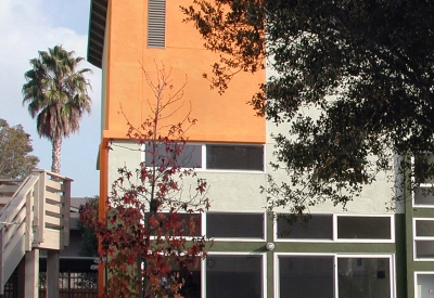 Exterior view of the colorful community building and courtyard at Stoney Pine Villa in Sunnyvale, California.