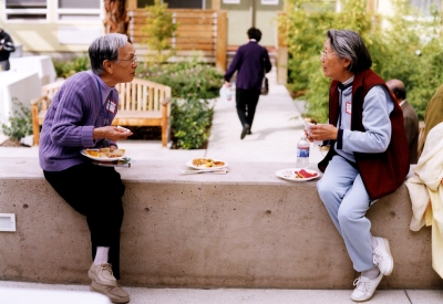 Two residents sitting in the courtyard at Mabuhay Court in San Jose, Ca.