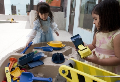 Two children playing in a sandbox at Paseo Senter in San Jose, California.