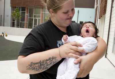 Mother holding her baby on the playground at Paseo Senter in San Jose, California.