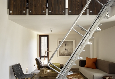 Interior view of the living room and metal stairs inside Zero Cottage in San Francisco.