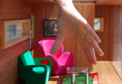 A hand inside the Modularean Eco House fixing the furniture.