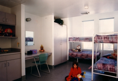 Child playing in a room with four bunkbeds at Sunrise Village in Fremont, California.