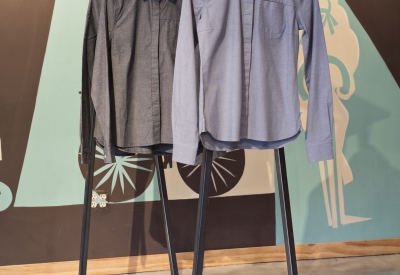 Detail of shirts hanging from a merchandise fixture inside Huckleberry Bicycles in San Francisco.