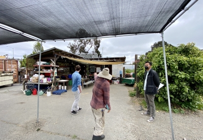 Three people standing visiting the site of the Farm2Market Shade Trellis in Alameda, California.