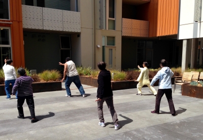 Residents participating in a Tai Chi class in the courtyard of Lakeside Senior Housing in Oakland, Ca
